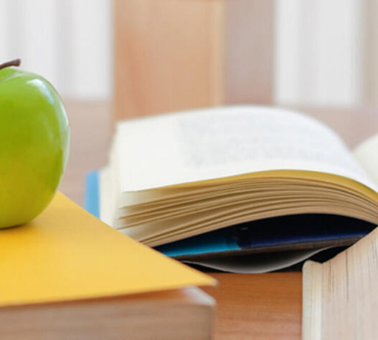 Education books on desk with apple